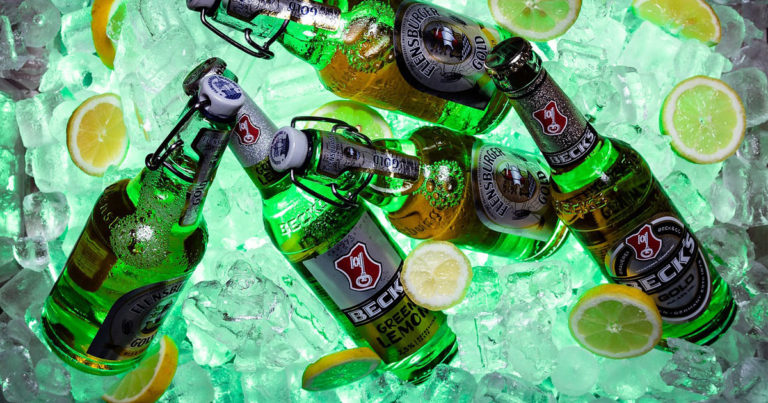 Green beer bottles in ice with lemon slices - This is a method of how to chill a beer fast