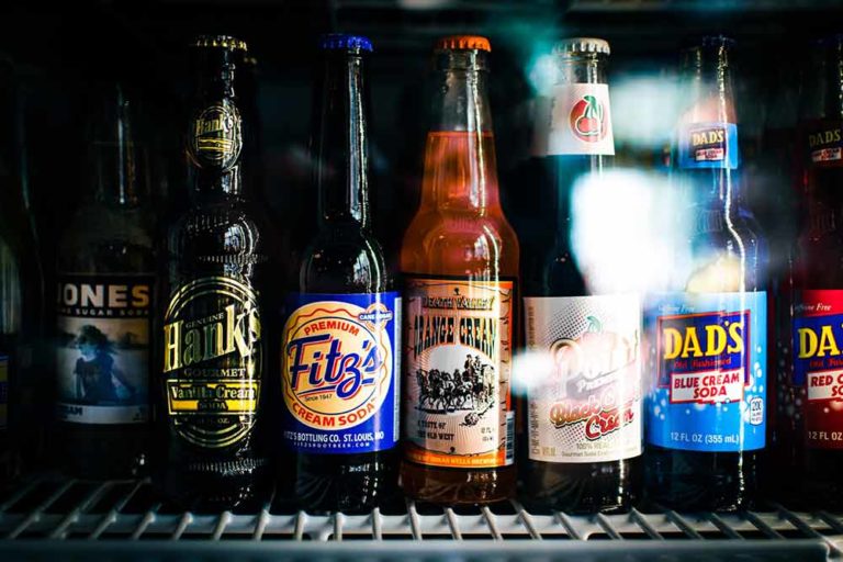 Best beer fridge temperature. A row of beer bottles inside a beer refrigerator.