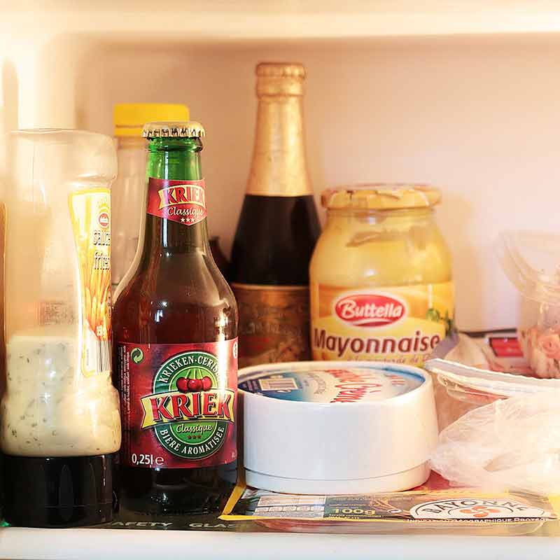 Ideal beer fridge temperature - beer bottle in a standard fridge surrounded by food and other drinks